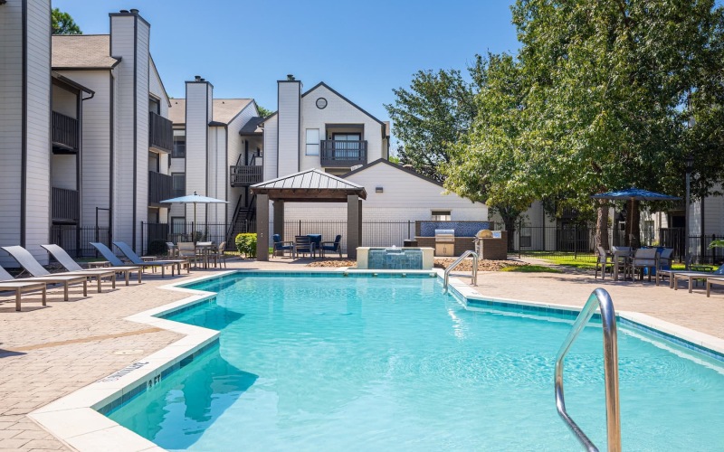 pool area with reclining seats and landscaping