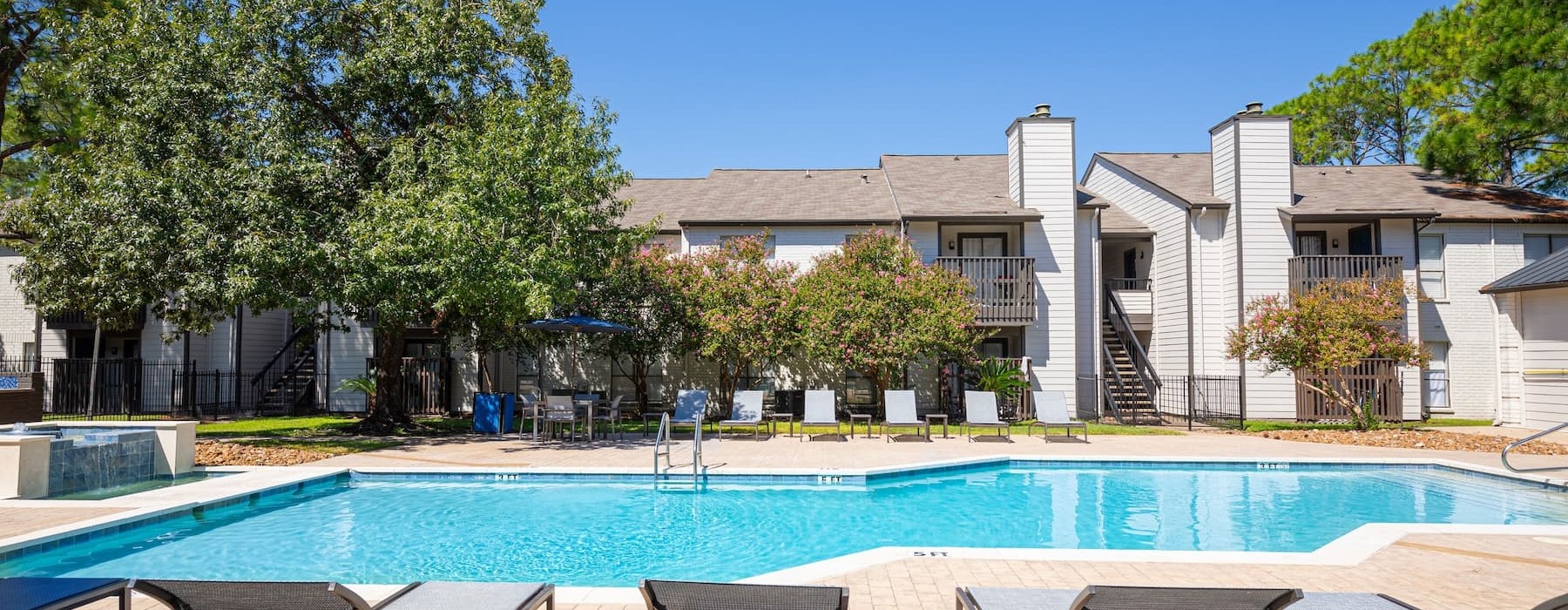 pool with reclining seats and nearness to apartments