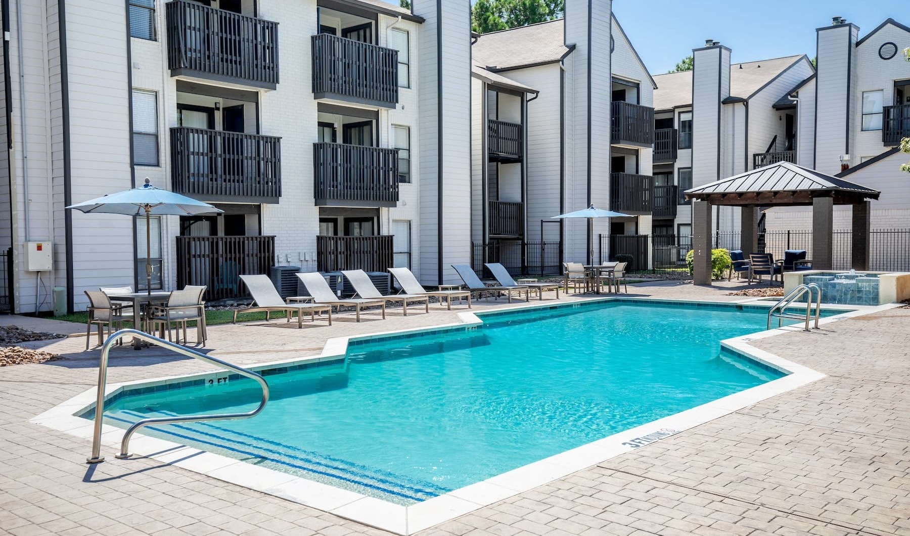 pool with reclining seats and lush landscaping